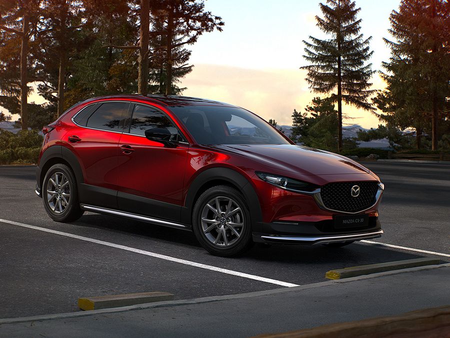 Der Mazda CX-30 auf einem Parkplatz in der Nähe von einem Wald