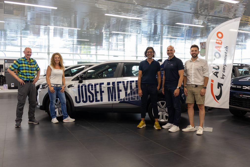 Die Personen von Josef Meyer und CARPLANET vor den neuen Fahrzeugen im Showroom