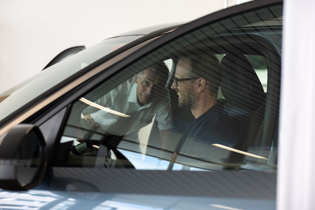 Person lachend im Auto, welche alle wichtigen Funktionen erklärt bekommt